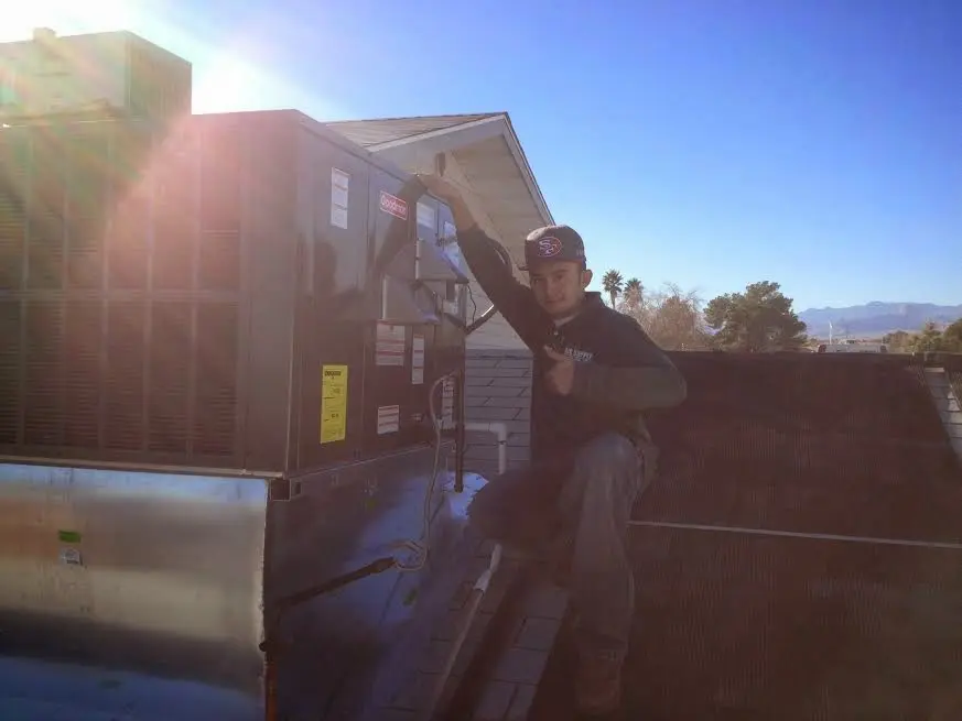 HVAC technician performing HVAC Inspection on a rooftop unit in Smiths Station